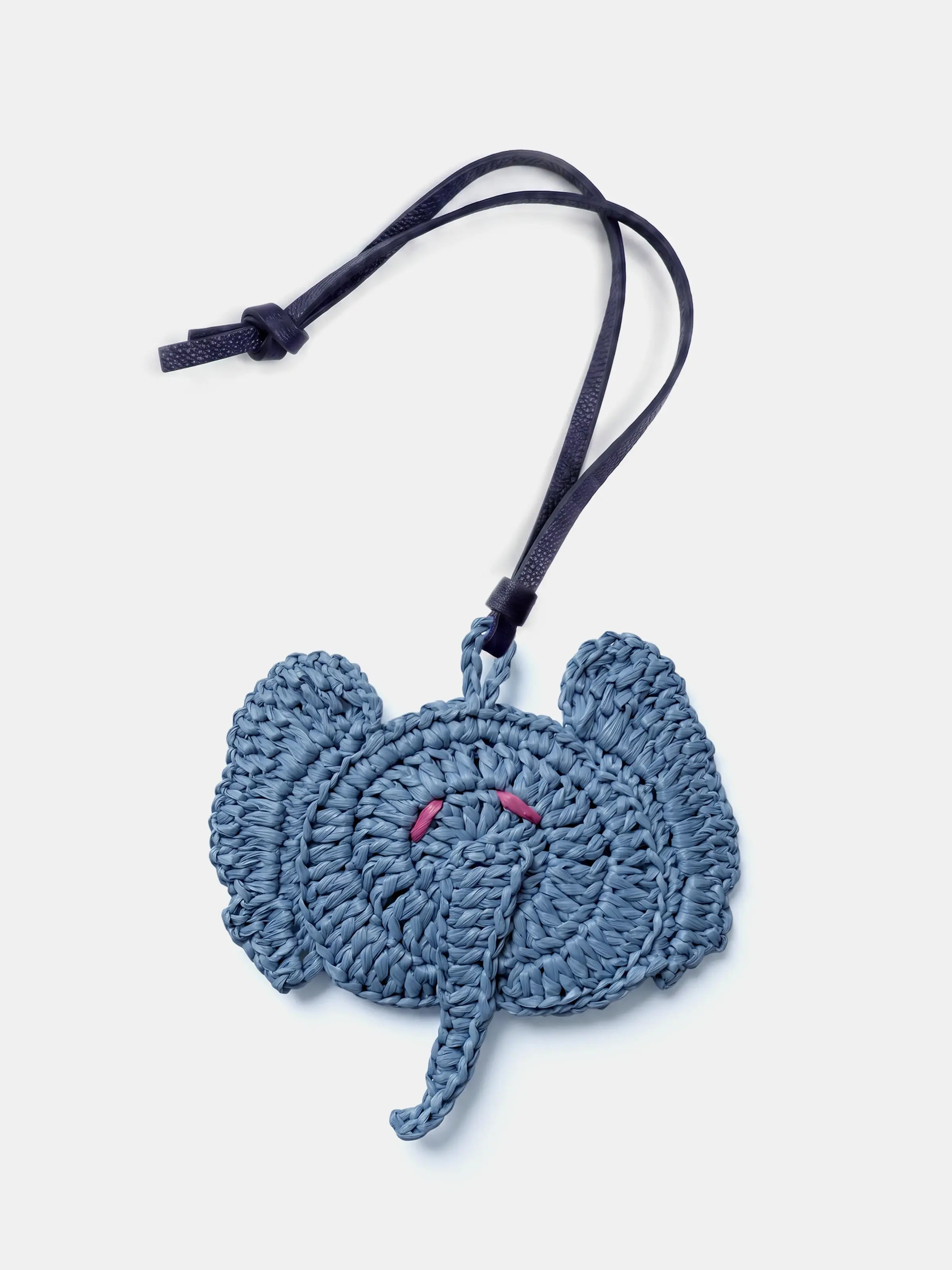 A woven elephant raffia bag charm in a dusty slate blue color, featuring small pink embroidered eyes and a black hanging strap with a knot, shown on a plain white background.
