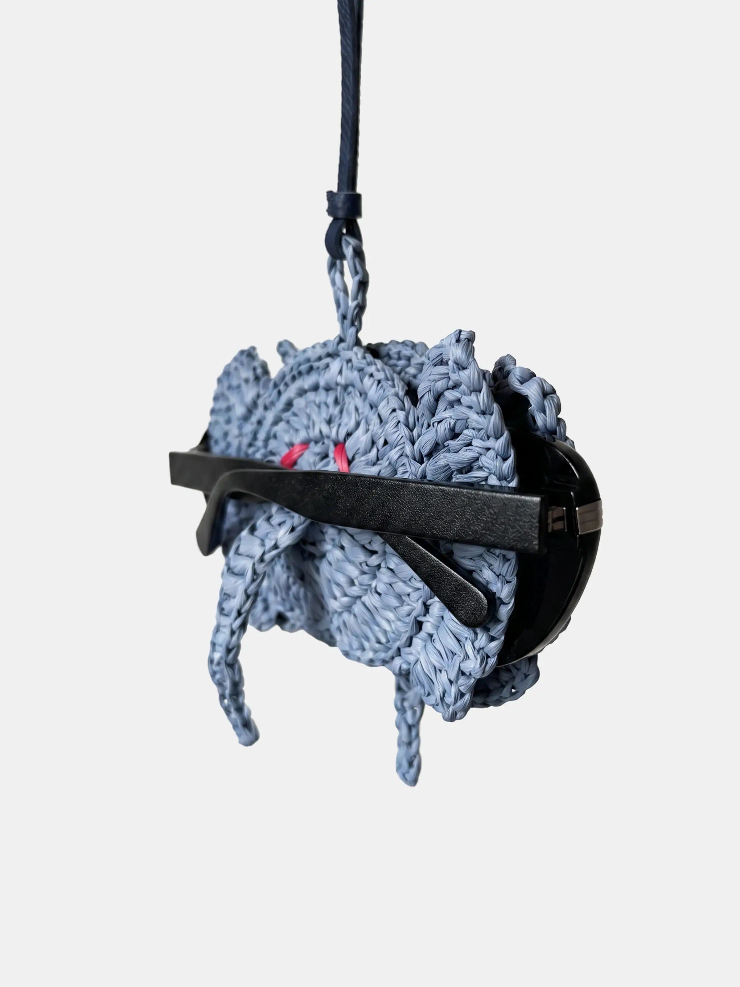 A light blue-gray knitted elephant charm that holds glasses