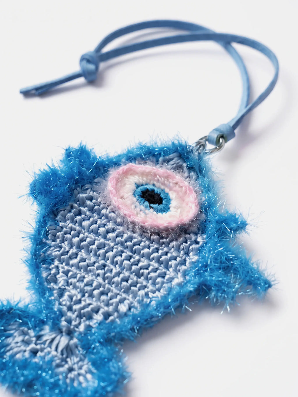 a woven raffia fish charm with a leather strap