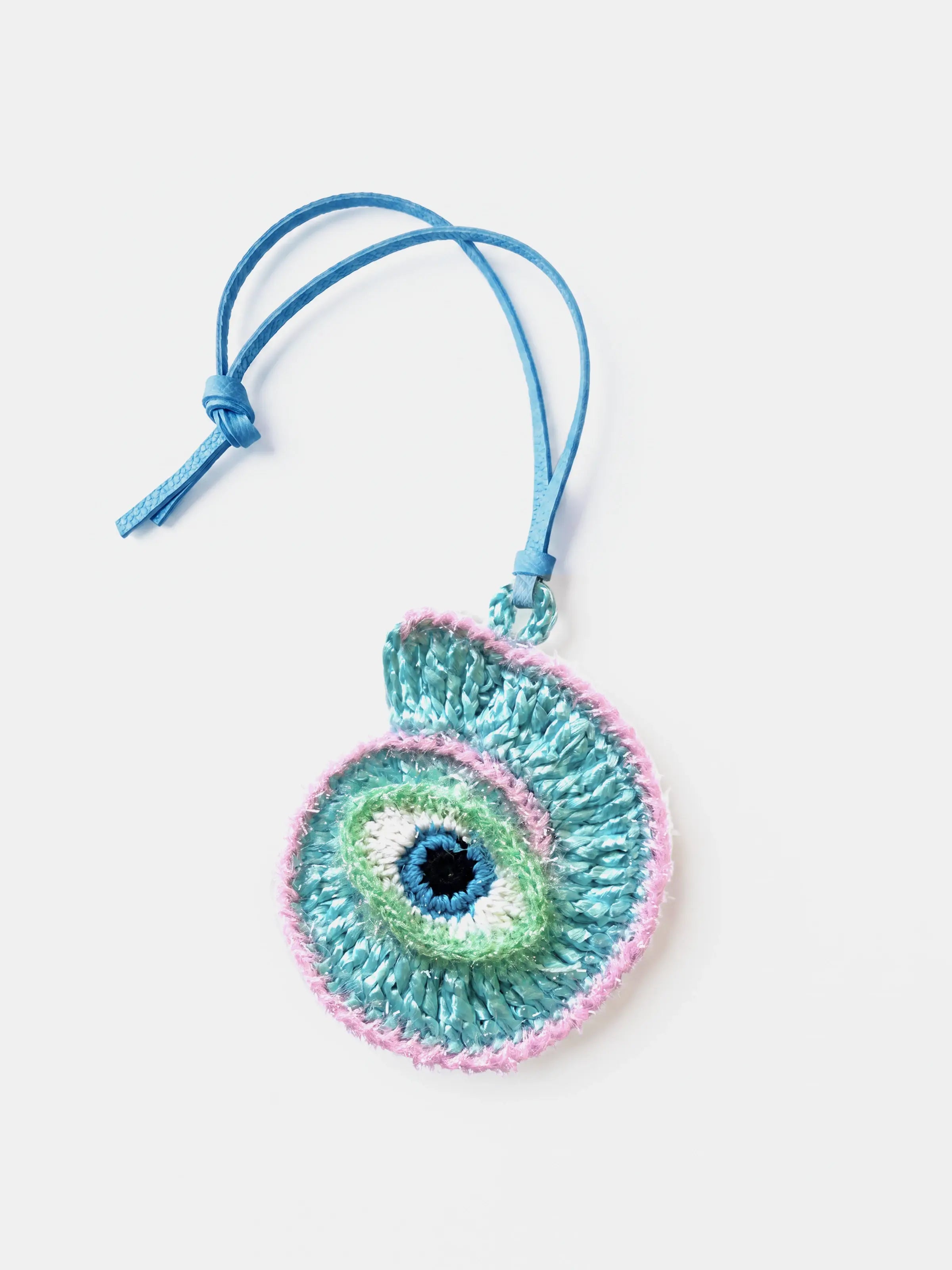 A crocheted conch raffia charm with a blue leather strap