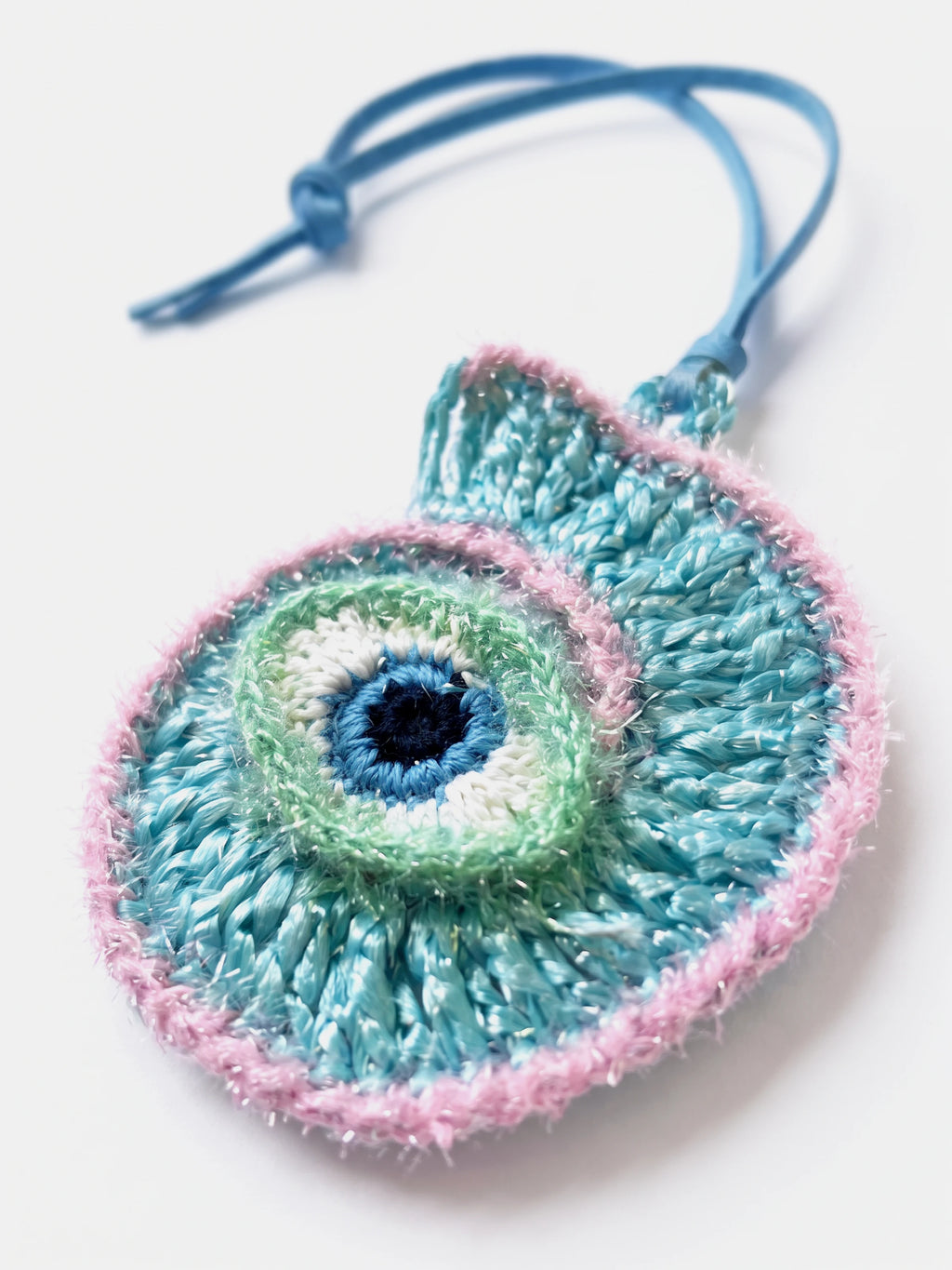 A handmade woven conch raffia cham with evil eye