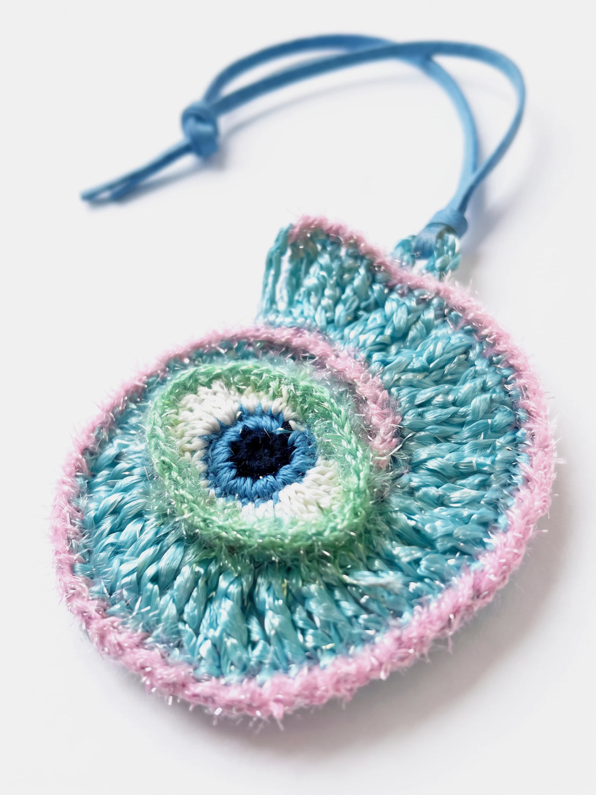 A handmade woven conch raffia cham with evil eye