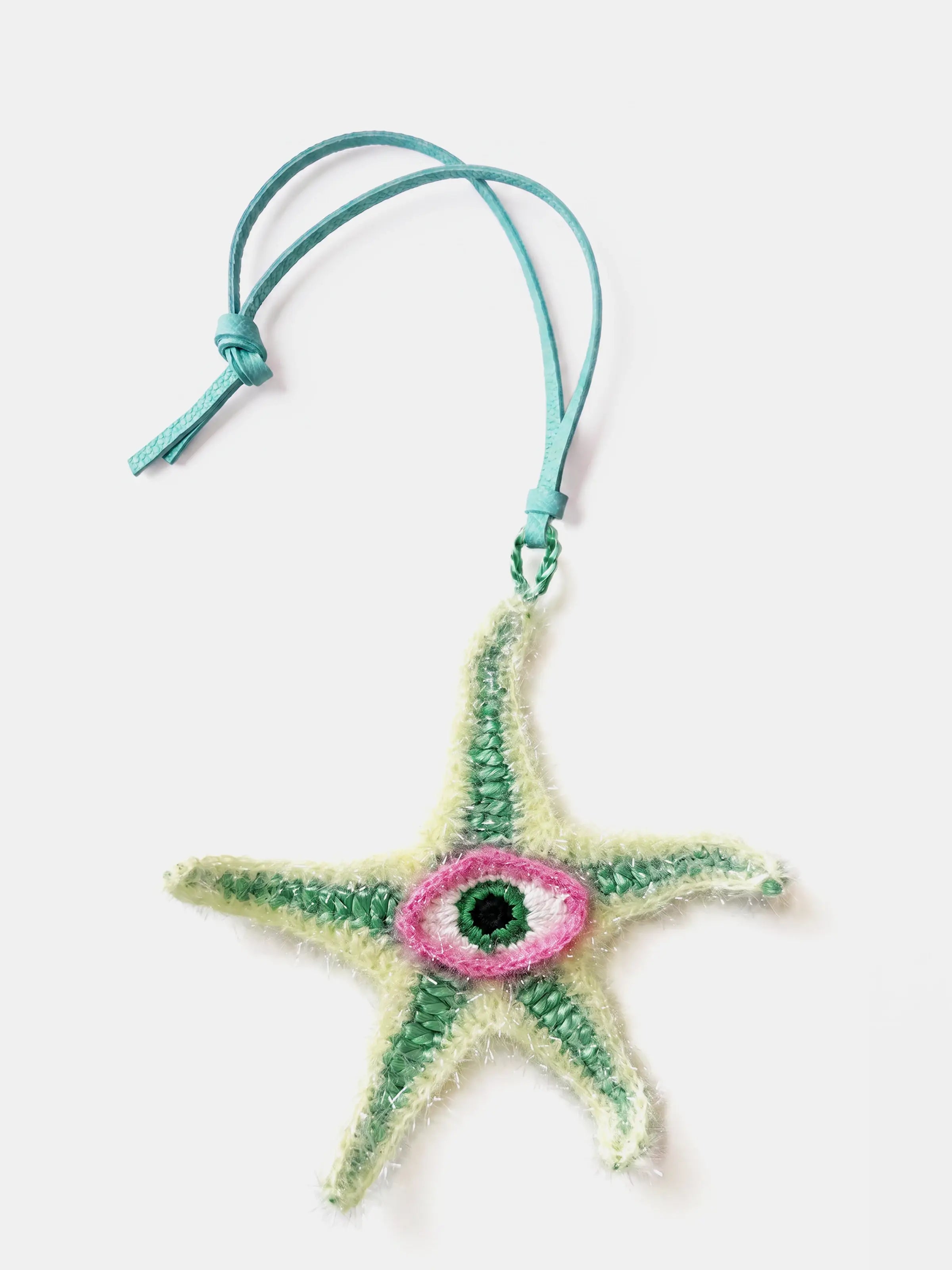 A handmade raffia starfish bag charm with a turquoise leather hanging cord