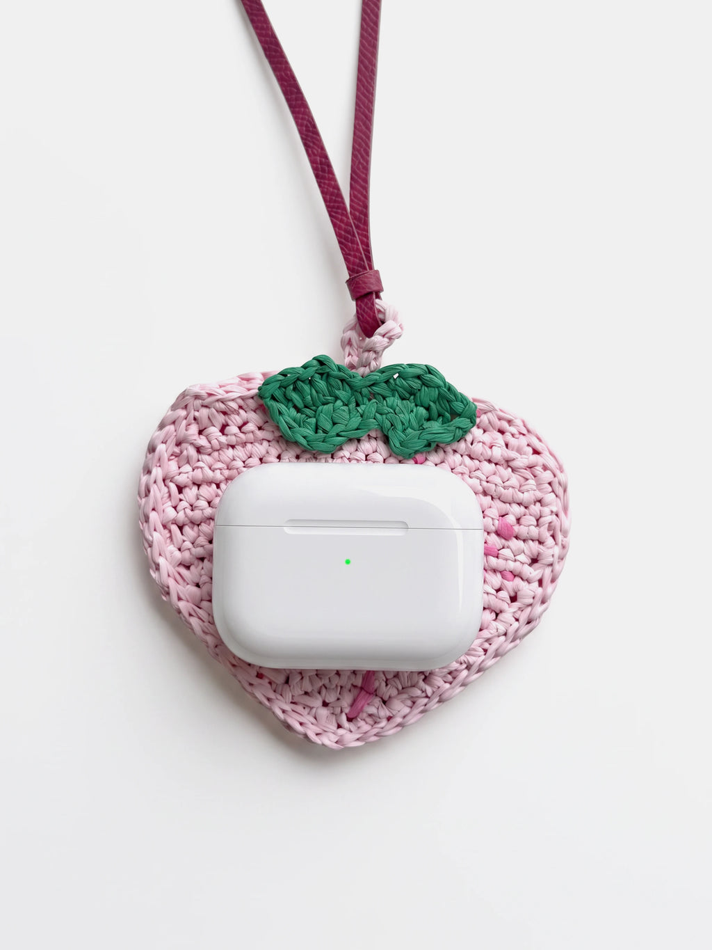 a pink peach raffia charm and earbuds pouch