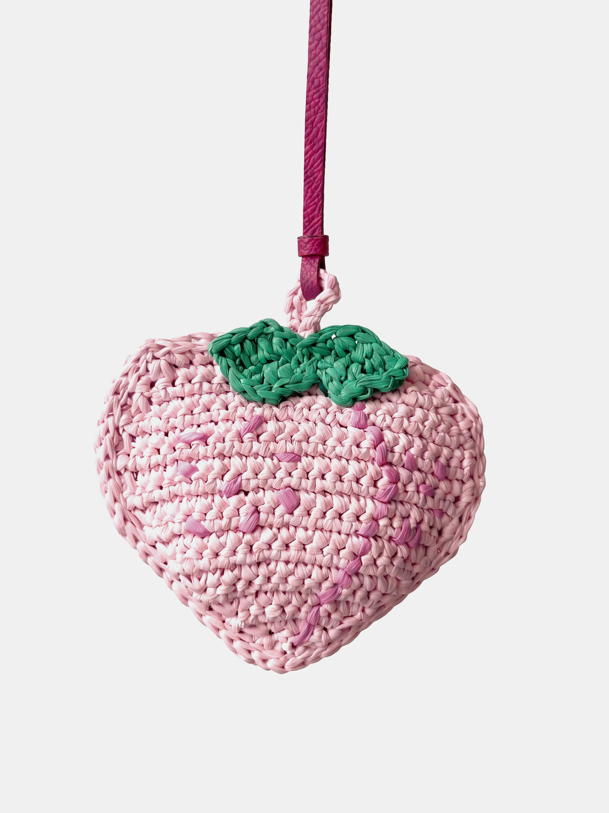 a pink peach raffia charm that holds earbuds