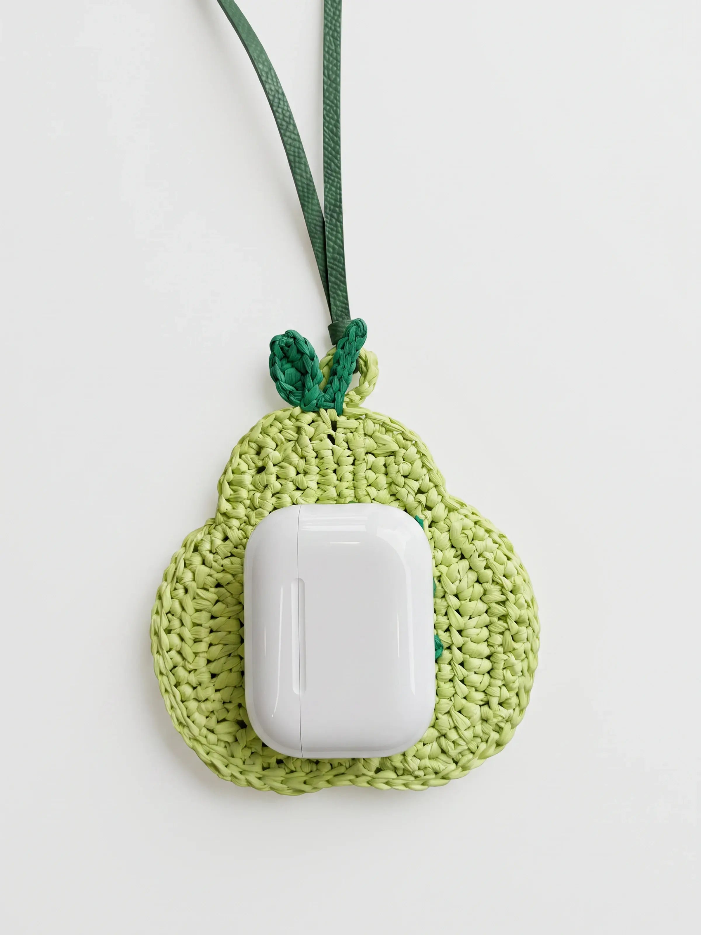 A light green pear charm with AirPods Pro