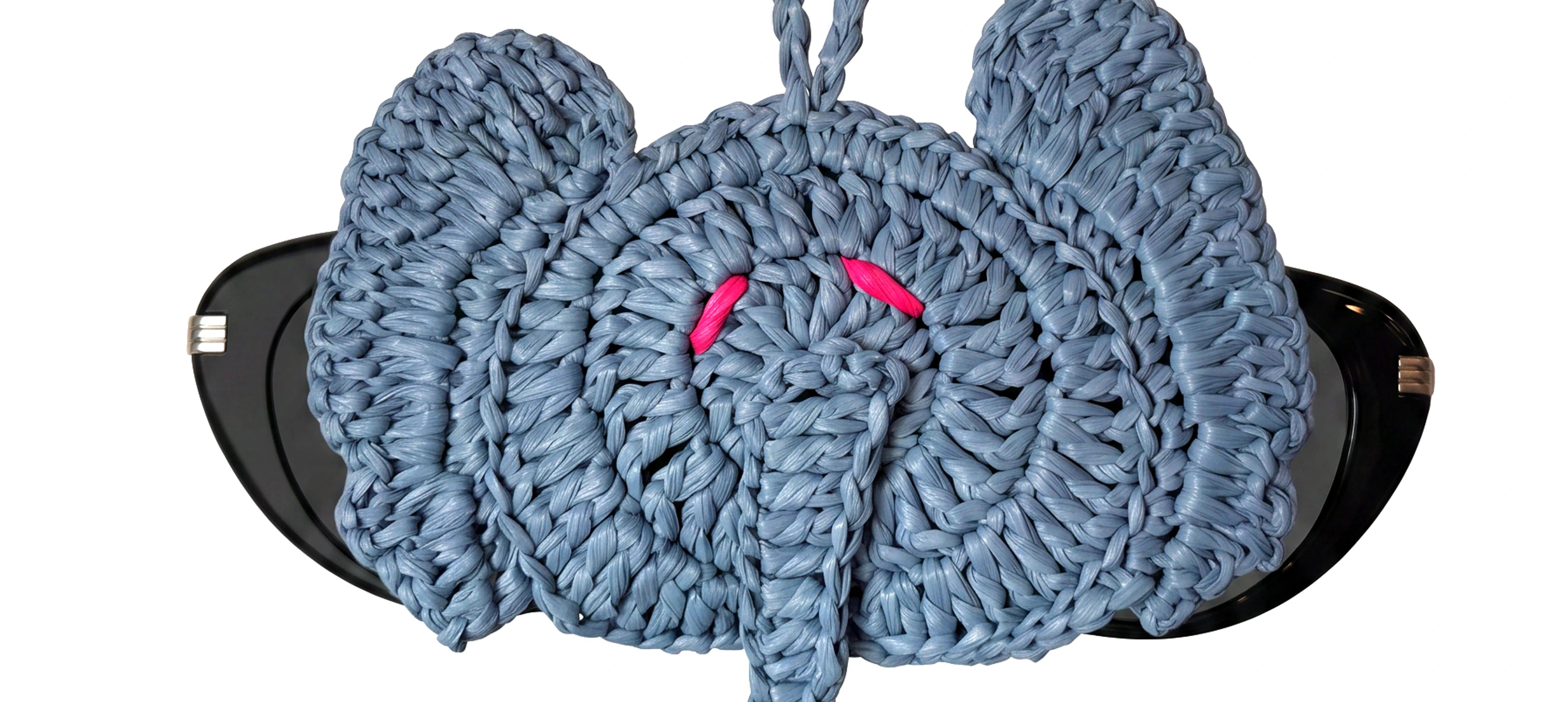 a grey elephant raffia charm holding a pair of glasses