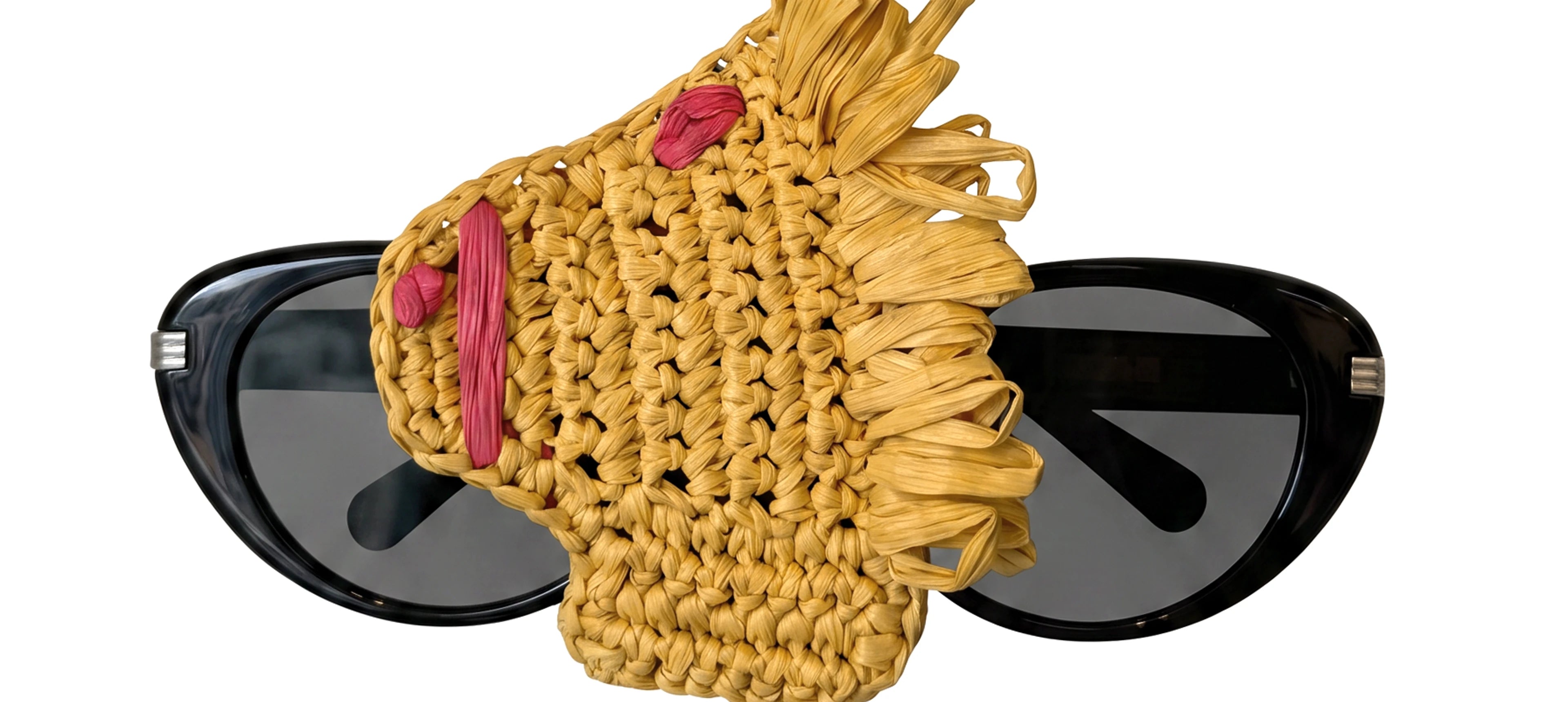 a yellow horse head raffia charm holding a pair of glasses