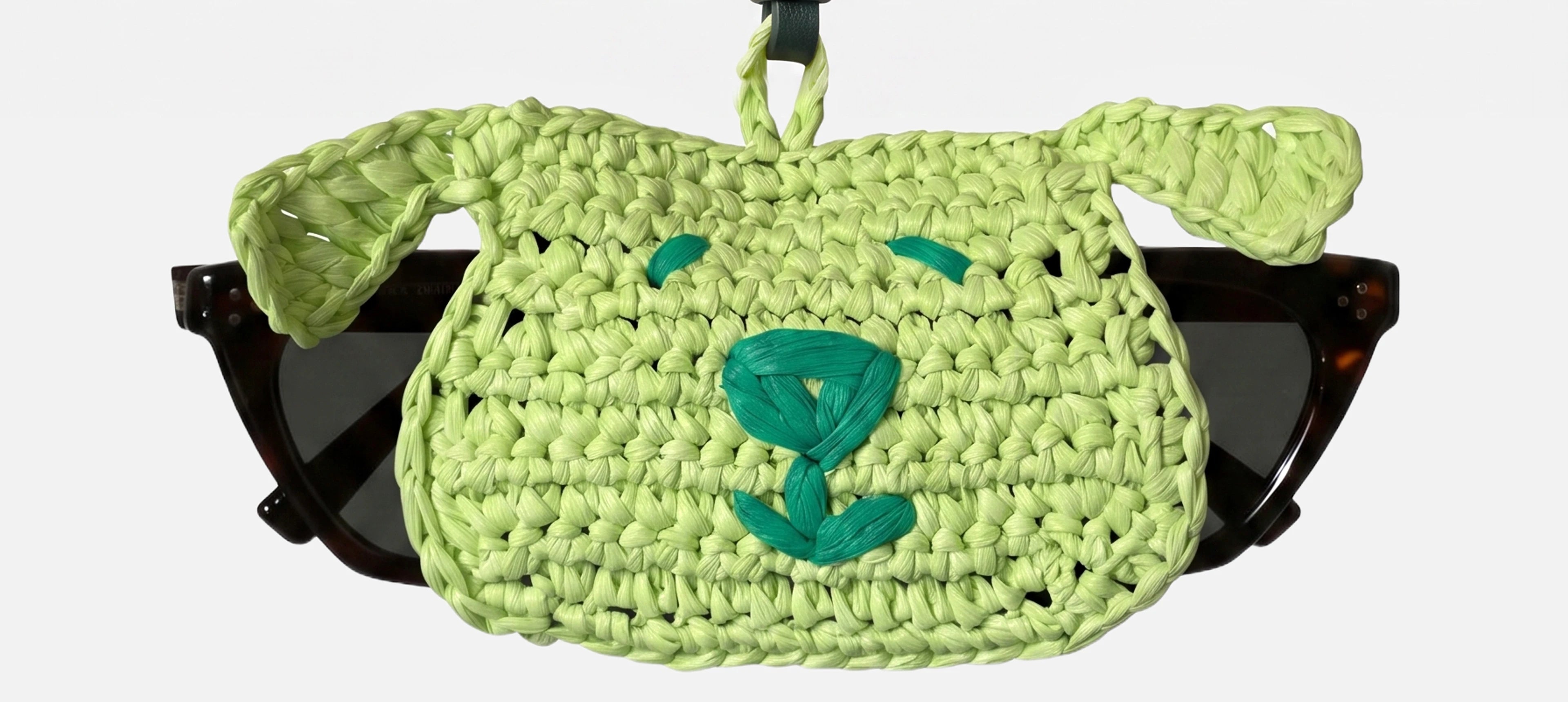 a light green dog head charm holding a pair of glasses
